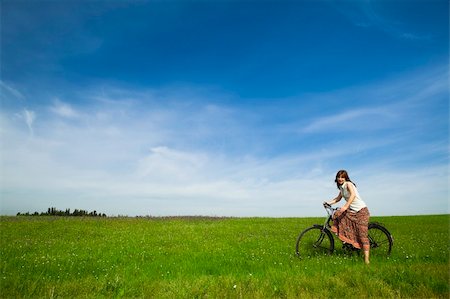 simsearch:400-04201795,k - Happy young woman with a vintage bicycle on a green meadow Fotografie stock - Microstock e Abbonamento, Codice: 400-04225058