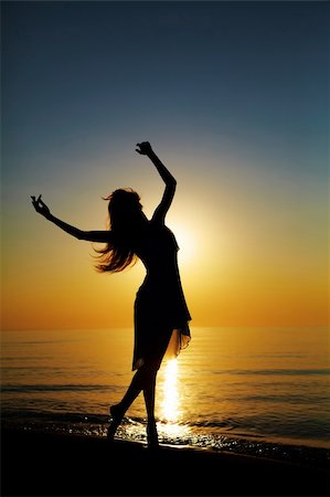 Girl dances on the beach at sunset. Natural light and dark. Artistic colors added. Vertical photo Stock Photo - Budget Royalty-Free & Subscription, Code: 400-04225705