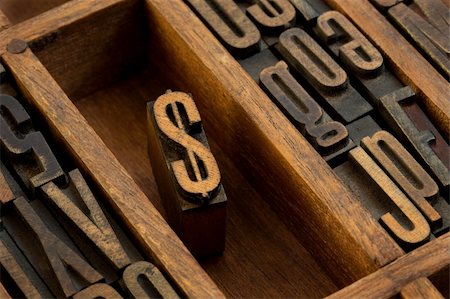 financial or monetary concept,  dollar symbol - vintage letterpress wooden type (condensed gothic) in old printer drawer among other letters stained by dark ink Stock Photo - Budget Royalty-Free & Subscription, Code: 400-04226702