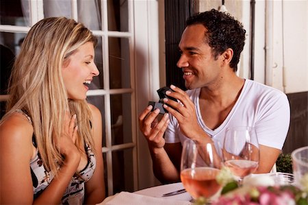 A man giving a ring as a gift to a female in an outdoor cafe Foto de stock - Super Valor sin royalties y Suscripción, Código: 400-04227031