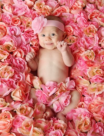 Adorable smiling baby girl lying in a bed of pink roses Photographie de stock - Aubaine LD & Abonnement, Code: 400-04227523