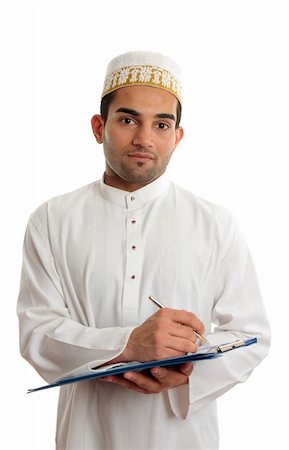 Homme d'affaires arabes de race mélangée portant le traditionnel costume du Moyen-Orient et l'or topi brodé chapeau.  Il est tenue d'un dossier de presse-papiers et l'écriture.  Fond blanc. Photographie de stock - Aubaine LD & Abonnement, Code: 400-04227545