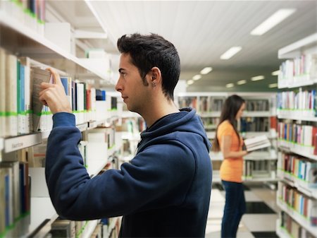 simsearch:6108-06166190,k - female and male college students choosing textbook from shelves in library. Horizontal shape, side view, waist up, focus on foreground Stockbilder - Microstock & Abonnement, Bildnummer: 400-04228169