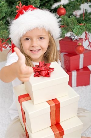 simsearch:400-06477682,k - Happy little girl with lots of christmas presents giving the thumbs up sign Stock Photo - Budget Royalty-Free & Subscription, Code: 400-04229157