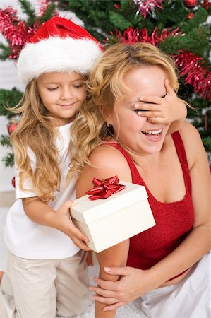 Surprise christmas present - little girl and woman in front of the decorated tree Stock Photo - Budget Royalty-Free & Subscription, Code: 400-04229158
