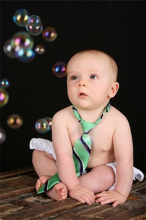Cute baby boy sitting on an antique trunk looking at bubbles Stock Photo - Budget Royalty-Free & Subscription, Code: 400-04229451