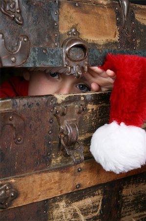 simsearch:400-05284316,k - Serious boy with a christmas hat peeping from inside an antique trunk Stockbilder - Microstock & Abonnement, Bildnummer: 400-04229626