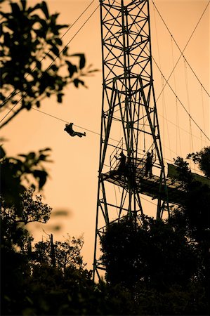 simsearch:400-04729405,k - Silhoutte of tourists on zip line in Costa Rica Photographie de stock - Aubaine LD & Abonnement, Code: 400-04220706
