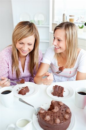 simsearch:400-04729451,k - Merry female friends eating a chocolate cake in the kitchen at home Stock Photo - Budget Royalty-Free & Subscription, Code: 400-04220778