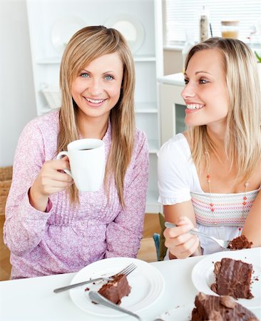 simsearch:400-04212407,k - Joyful female friends eating a chocolate cake and drinking in the kitchen at home Stock Photo - Budget Royalty-Free & Subscription, Code: 400-04220779