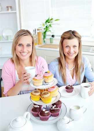 simsearch:400-04729451,k - Portrait of two female friends eating pastries and drinking coffee in the kitchen at home Stock Photo - Budget Royalty-Free & Subscription, Code: 400-04220781
