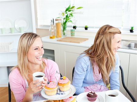 simsearch:400-04729451,k - Two laughing female friends eating pastries and drinking coffee in the kitchen at home Stock Photo - Budget Royalty-Free & Subscription, Code: 400-04220782