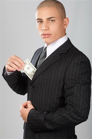 A young good looking businessman on a gray background. Foto de stock - Super Valor sin royalties y Suscripción, Código: 400-04223064