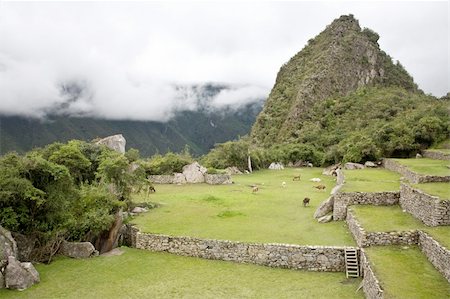 Machu Picchu is a pre-Columbian Inca site located 2,430 metres (8,000 ft) above sea level. It is situated on a mountain ridge above the Urubamba Valley in Peru, which is 80 kilometres (50 mi) northwest of Cusco and through which the Urubamba River flows. The river is a partially navigable headwater of the Amazon River. Often referred to as "The Lost City of the Incas", Machu Picchu is one of the m Foto de stock - Super Valor sin royalties y Suscripción, Código: 400-04223184