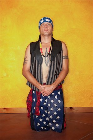 simsearch:400-04732676,k - Kneeling Native American man with tattoos and vest Foto de stock - Royalty-Free Super Valor e Assinatura, Número: 400-04223747