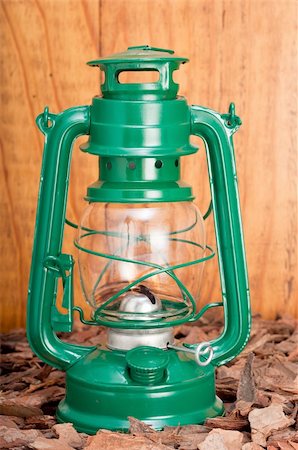 Green lantern on bark chips against wooden background Fotografie stock - Microstock e Abbonamento, Codice: 400-04223964