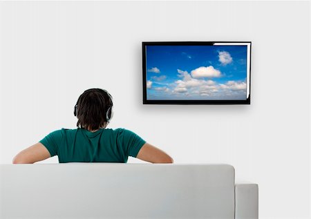 elegant tv room - Rear view from a young man seated on the couch watching tv Foto de stock - Super Valor sin royalties y Suscripción, Código: 400-04234064