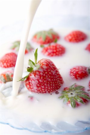 A bowl of milk with  red strawberries. Milk poured into the bowl Photographie de stock - Aubaine LD & Abonnement, Code: 400-04234182