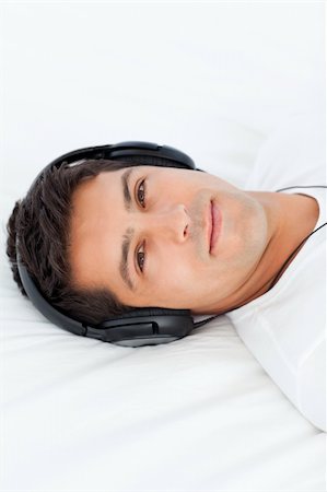 simsearch:6108-08725387,k - Serious man with headphones on lying on his bed at home Stock Photo - Budget Royalty-Free & Subscription, Code: 400-04235202