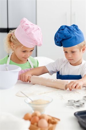 simsearch:400-04306517,k - Little girl looking at her serious brother using a rolling pin in the kitchen Stock Photo - Budget Royalty-Free & Subscription, Code: 400-04235214