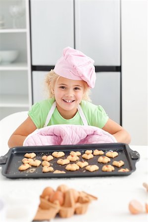 Adorable little girl showing her cookies to the camera standing in the kicthen Stock Photo - Budget Royalty-Free & Subscription, Code: 400-04235225