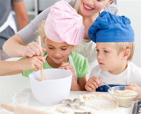 Two children and their mother stiring a preparation for cookies together in the kitchen Stock Photo - Budget Royalty-Free & Subscription, Code: 400-04235221