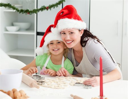 Portrait of a cute girl with her mother baking Christmas cookies in the kitchen Stock Photo - Budget Royalty-Free & Subscription, Code: 400-04235232