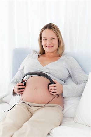 simsearch:400-04767824,k - Future mom putting headphones on her belly lying on a bed Foto de stock - Royalty-Free Super Valor e Assinatura, Número: 400-04235253
