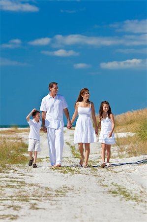 simsearch:400-04235471,k - A happy family of mother, father and two children, son and daughter, walking holding hands and having fun in the sand of a sunny beach Stock Photo - Budget Royalty-Free & Subscription, Code: 400-04235470