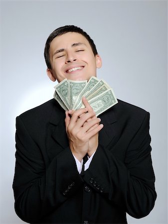 simsearch:400-04150475,k - Expressions - Young handsome business man in black suit and tie counting money. gray background Foto de stock - Super Valor sin royalties y Suscripción, Código: 400-04235647