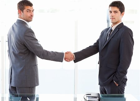 simsearch:400-04606211,k - Two charismatic businessmen shaking hands standing in the office at work Stockbilder - Microstock & Abonnement, Bildnummer: 400-04235822