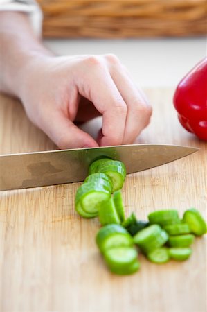 Close-up of a caucasian man cutting a cucumber in the kitchen at home Stock Photo - Budget Royalty-Free & Subscription, Code: 400-04235884