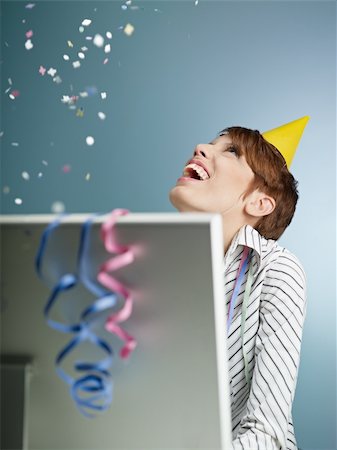 party streamers on white background - caucasian woman looking at confetti being thrown in office. Vertical shape, side view, waist up, copy space Stock Photo - Budget Royalty-Free & Subscription, Code: 400-04235903