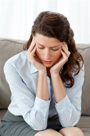 Tired businesswoman having a headache on the sofa at home Stock Photo - Budget Royalty-Free & Subscription, Code: 400-04237319