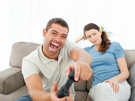 Pretty woman waiting for her boyfrind playing video games on the sofa at home Stock Photo - Budget Royalty-Free & Subscription, Code: 400-04237350