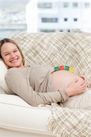 simsearch:400-04266869,k - Smiling future mom with baby letters on the belly in the living room Stock Photo - Budget Royalty-Free & Subscription, Code: 400-04237394