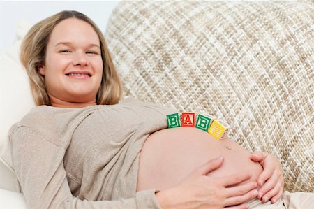 simsearch:400-04266869,k - Smiling future mom with baby letters on the belly in the living room Stock Photo - Budget Royalty-Free & Subscription, Code: 400-04237396