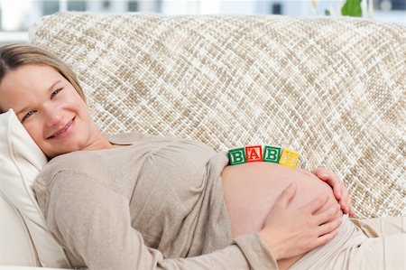 simsearch:400-04767824,k - Smiling future mom with baby letters on the belly in the living room Foto de stock - Royalty-Free Super Valor e Assinatura, Número: 400-04237392