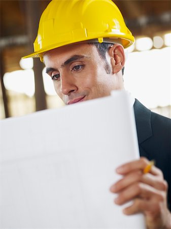 simsearch:400-04193857,k - caucasian male architect examining blueprint. Vertical shape, waist up, side view, copy space Foto de stock - Super Valor sin royalties y Suscripción, Código: 400-04238065