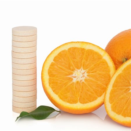 simsearch:400-08618279,k - Vitamin c tablet stack with orange fruit whole and in half with leaf sprig, over white background. Photographie de stock - Aubaine LD & Abonnement, Code: 400-04239188