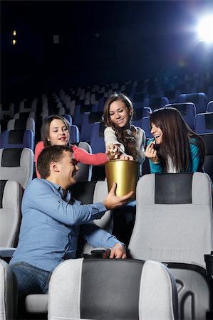 The young man at cinema gives girls pop-corn Stock Photo - Budget Royalty-Free & Subscription, Code: 400-04239292