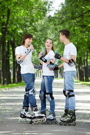 Three young people on rollers drink water Stock Photo - Budget Royalty-Free & Subscription, Code: 400-04239303