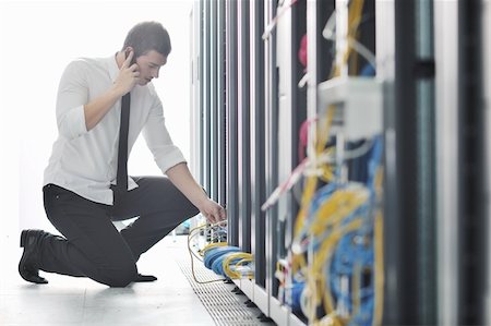fast wire - young business man computer science engeneer talking by cellphone at network datacenter server room asking  for help and fast solutions and services Stock Photo - Budget Royalty-Free & Subscription, Code: 400-04239437