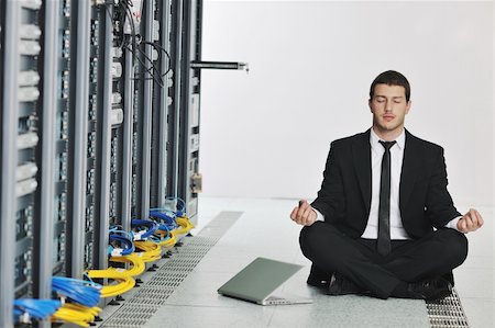 data backup - young handsome business man in black suit and tie practice yoga and relax at network server room while representing stres control concept Stock Photo - Budget Royalty-Free & Subscription, Code: 400-04239444