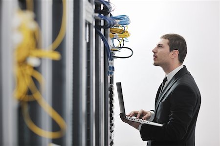 server room managers - young engeneer business man with thin modern aluminium laptop in network server room Stock Photo - Budget Royalty-Free & Subscription, Code: 400-04239447