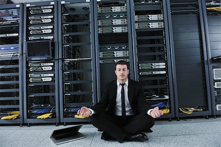 data backup - young handsome business man in black suit and tie practice yoga and relax at network server room while representing stres control concept Stock Photo - Budget Royalty-Free & Subscription, Code: 400-04239459
