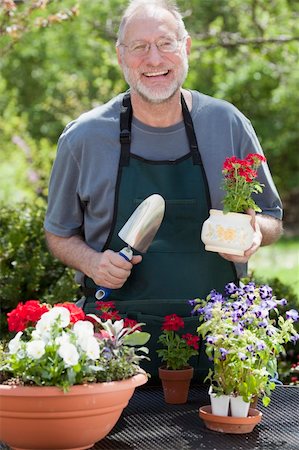 edbockstock (artist) - Man smiles at the camera while gardening with potted plants outdoors. Photographie de stock - Aubaine LD & Abonnement, Code: 400-04232362