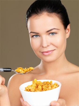 Portrait of beautiful woman, she eating cornflakes Stock Photo - Budget Royalty-Free & Subscription, Code: 400-04232704