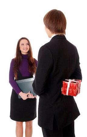 secretary flirting with boss - teen boy giving a gift to a girl. Isolated at white background Stock Photo - Budget Royalty-Free & Subscription, Code: 400-04233342