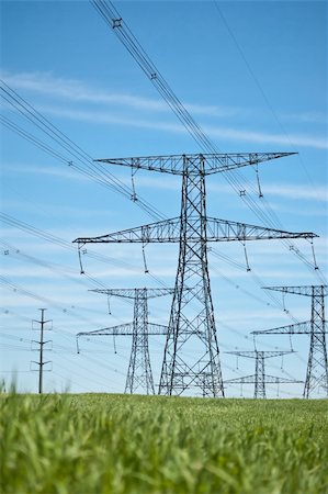 simsearch:400-04838002,k - Power lines running across a green field with blue sky in the background. Foto de stock - Royalty-Free Super Valor e Assinatura, Número: 400-04233530